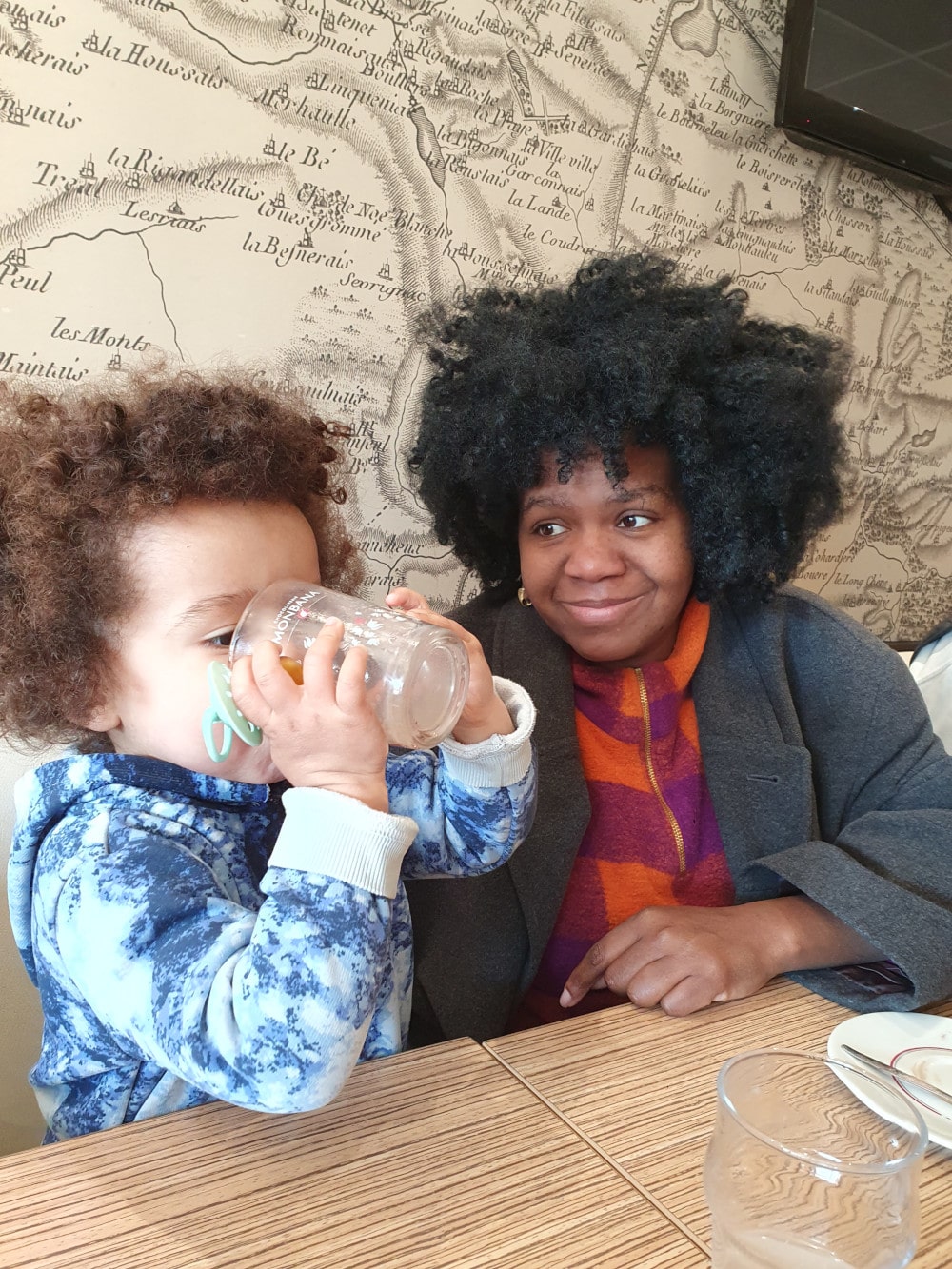 Edna regarde Siloë boire à la table du café